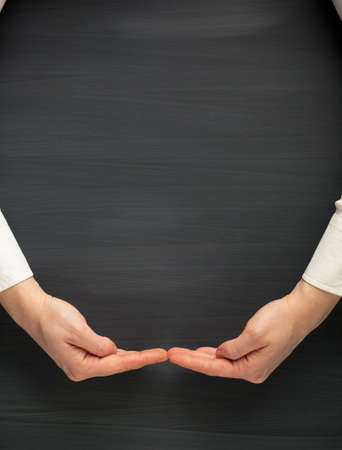 hands surrounding a blackboard backgroundの写真素材