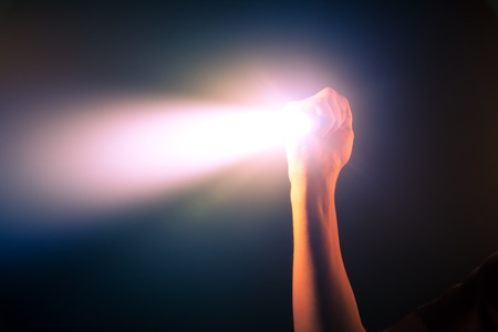 hand holding glowing pocket torch lightの写真素材