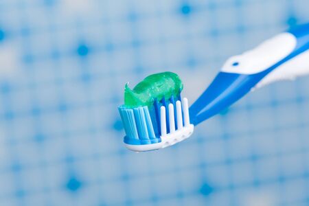 toothbrush against blue tile background