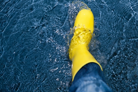 rubber boot splashing in the waterの写真素材