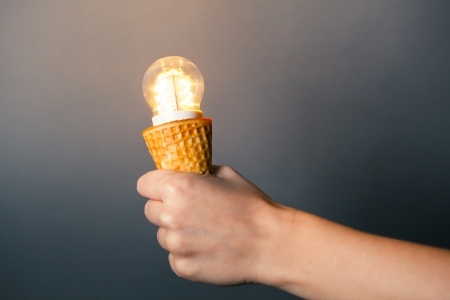 hand holding led lamp in ice cream cone, innovation conceptの写真素材