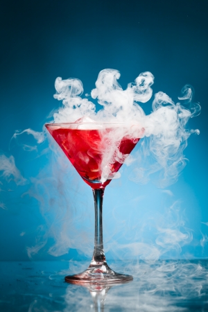 red cocktail with ice vapor, blue backgroundの写真素材