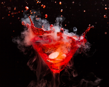 red cocktail with splash and ice vaporの写真素材