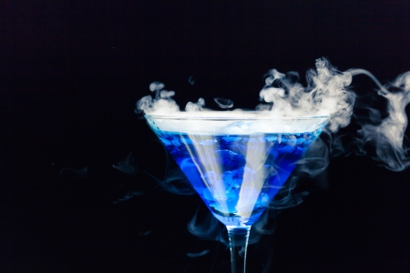 blue cocktail with splash and ice vaporの写真素材