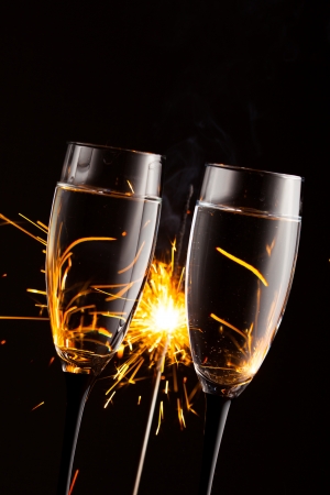 champagne glasses against christmas sparkler backgroundの写真素材