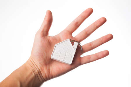 hand with house keychain isolated on white