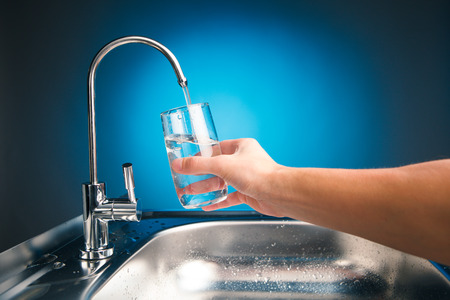 hand pouring a glass of water from filter tap hand pouring a glass of water from filter tap
