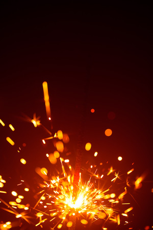 Christmas sparkler in haze with red lightの写真素材