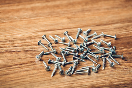screws fasteners hardware on wooden background