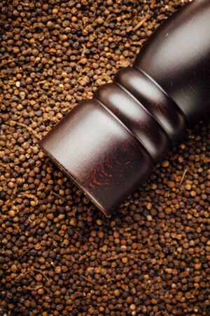 pepper mill on peppercorns backgroundの写真素材