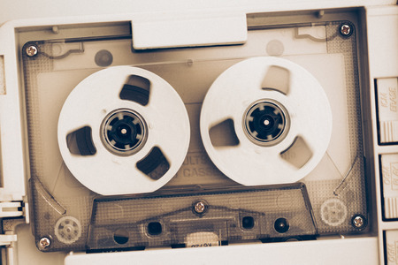 rewinding of vintage audio tape compact cassette, sepia tone with artistic film noiseの写真素材