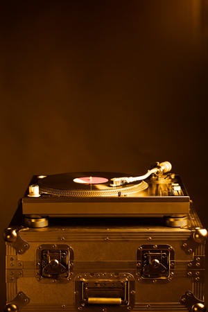 professional dj turntable on flight case, dark background, golden toneの写真素材