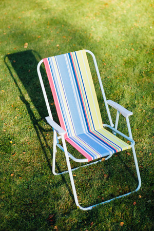 garden chair on green lawn backgroundの写真素材