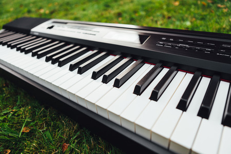 keys of electric piano, green grass backgroundの写真素材