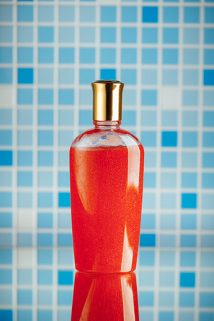 red shower gel on blue tile backgroundの写真素材