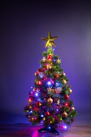 Christmas tree with festive lights, purple backgroundの写真素材