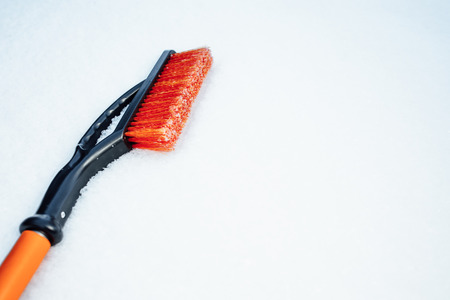 orange snow brush for car, snowflakes backgroundの写真素材