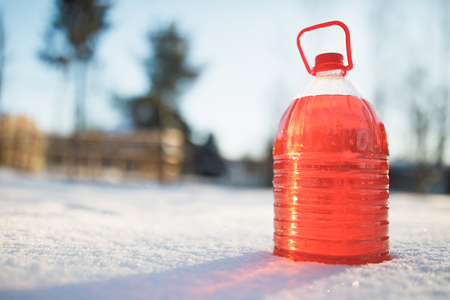 bottle with non-freezing windshield washer fluid, snow backgroundの写真素材