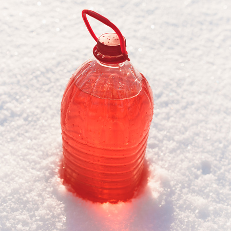 bottle with non-freezing windshield washer fluid, snow background