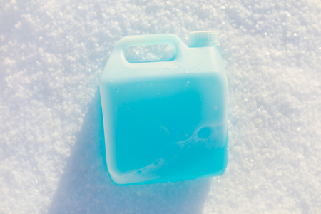 bottle with non-freezing windshield washer fluid, snow background
