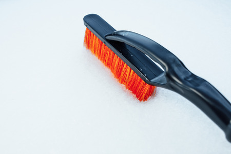 orange snow brush for car, snowflakes backgroundの写真素材