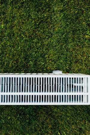 radiator mesh, green lawn background, ecological heating conceptの写真素材