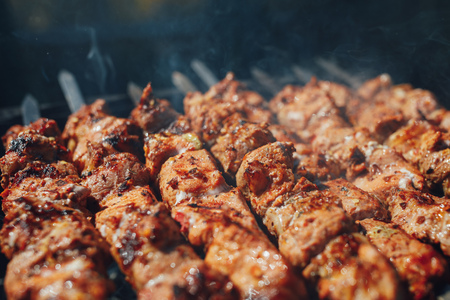 grilled barbecue meat on skewers with smokeの写真素材
