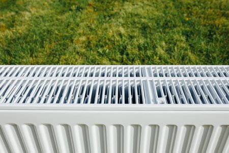 radiator mesh, green lawn background, ecological heating conceptの写真素材