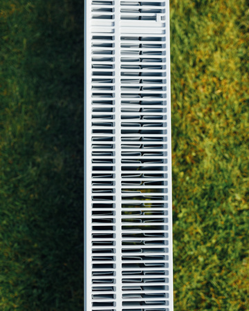 radiator mesh, green lawn background, ecological heating concept