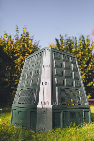 compost bin on green grass and foliage backgroundの写真素材