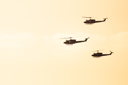 three helicopters flying against sunlight backgroundの写真素材