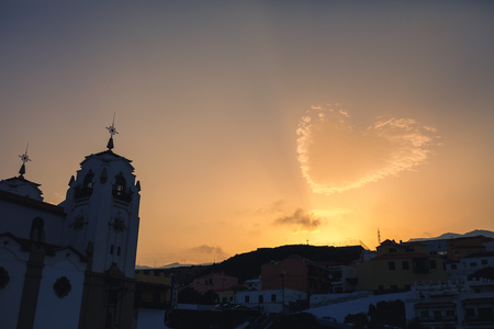 heart shaped cloud and church silhouette at sunsetの写真素材