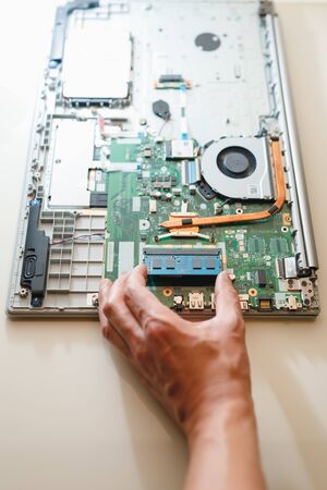 hand of repairman holding a ram sodimm memory module, laptop upgrade