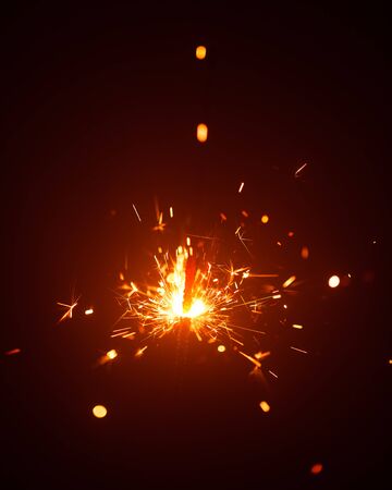Christmas sparkler in haze with red lightの写真素材