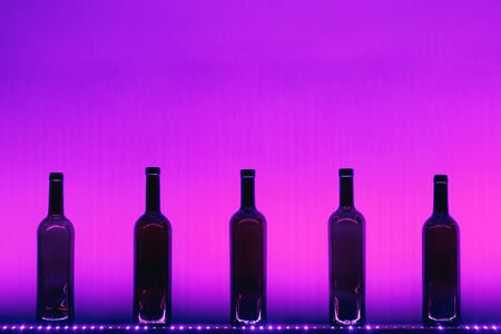 abstract empty wine bottles with purple led illuminationの写真素材