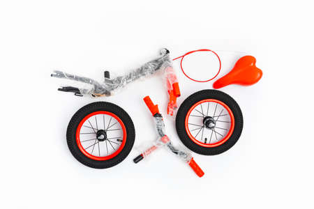 disassembled balance bike on white background