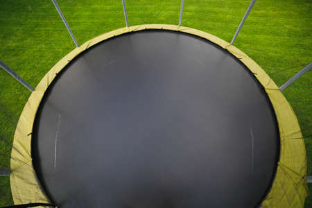 trampoline with big round mat on green lawnの写真素材