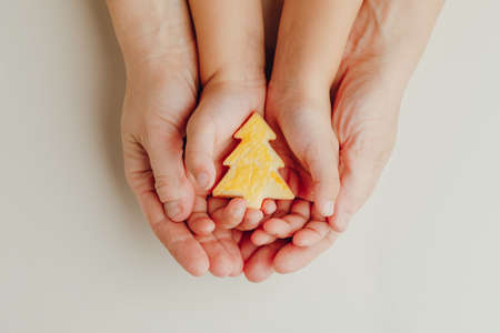 mother and child holding a Christmas tree cookie in handsの写真素材