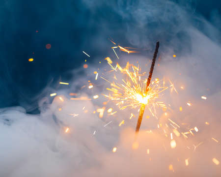 fire sparkler in dense smoke, abstract Christmas firework backgroundの写真素材