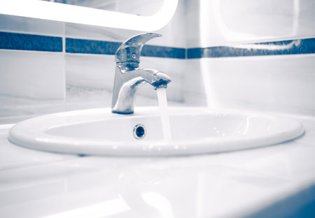 tap faucet with flowing water, blue toneの写真素材