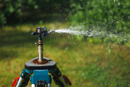 garden sprinkler on a tripod watering new lawnの写真素材