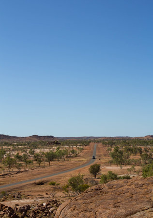 Lonely Car on a long highway trough the Australian Outback.MT ISA, Queensland, Australia.の写真素材