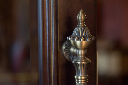 Metal door handle on a wooden door. Open wooden door with metal handle.の写真素材