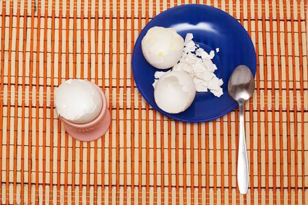 Eaten egg. Eggshell and spoon on the blue plate.