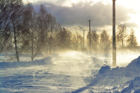 The strong wind sweeps snow on the winter roadの写真素材