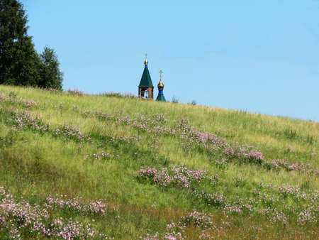 Rustic church in winter and summer decorates rural landscapeの写真素材