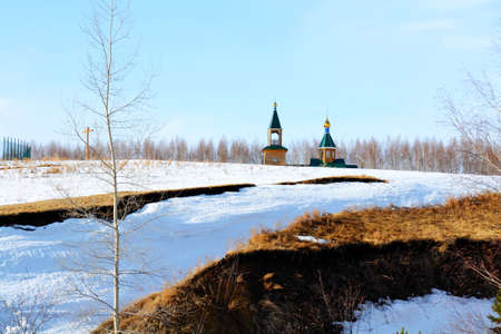 Rustic church in winter and summer decorates rural landscape