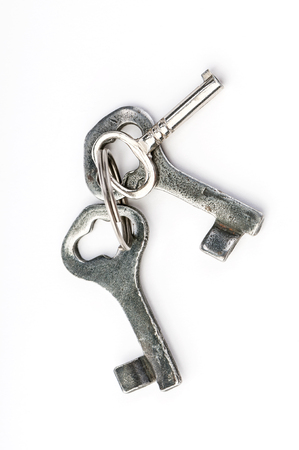 bunch of old iron keys close-up on white backgroundの写真素材