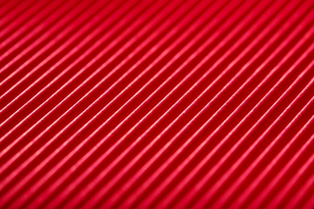 bright red with white diagonal stripes paper texture close-up backgroundの写真素材