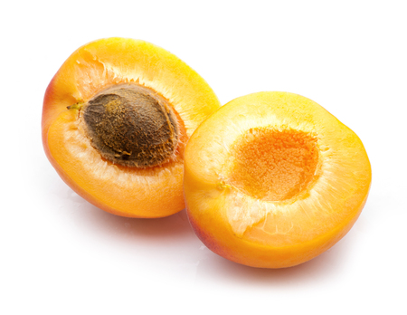 two apricot halves with stone close-up on white backgroundの写真素材